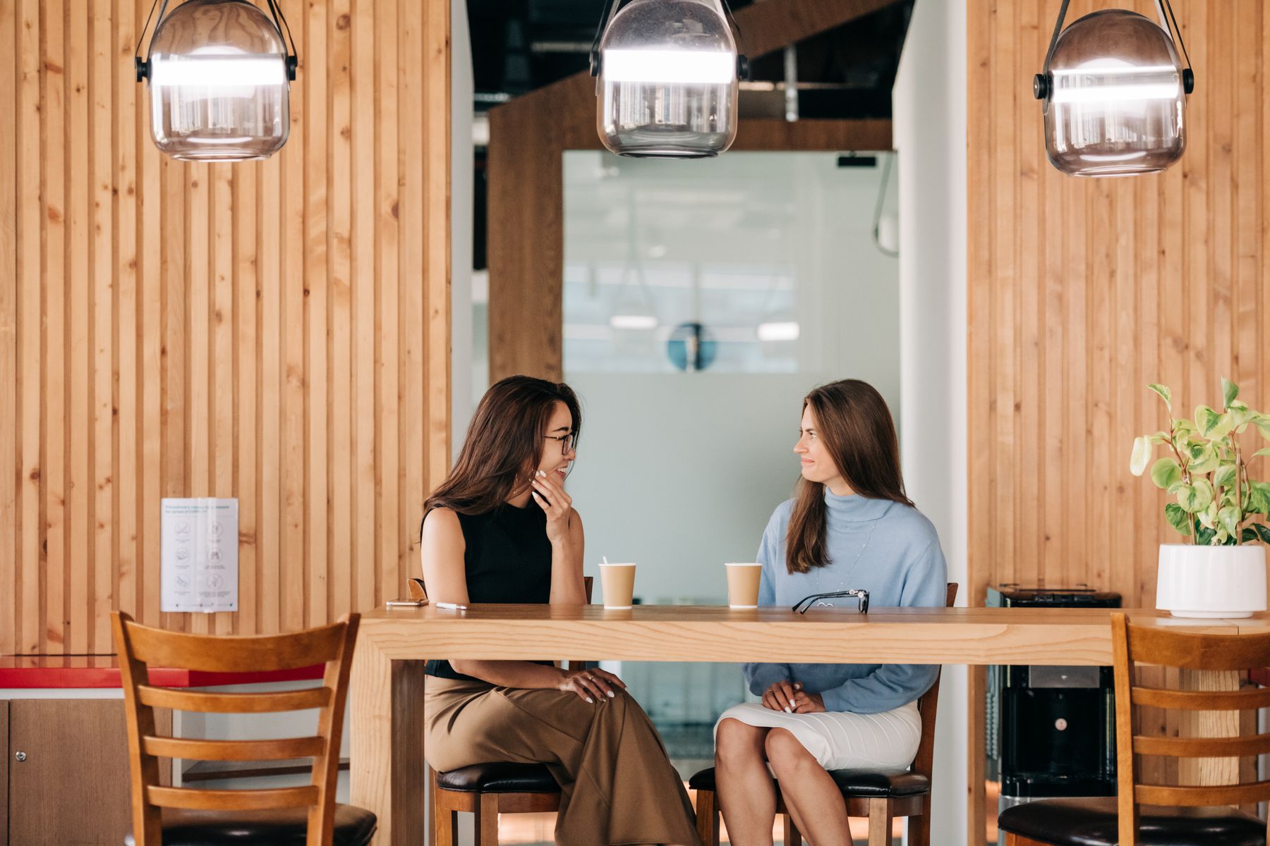 Two colleagues in warm conversation over coffee